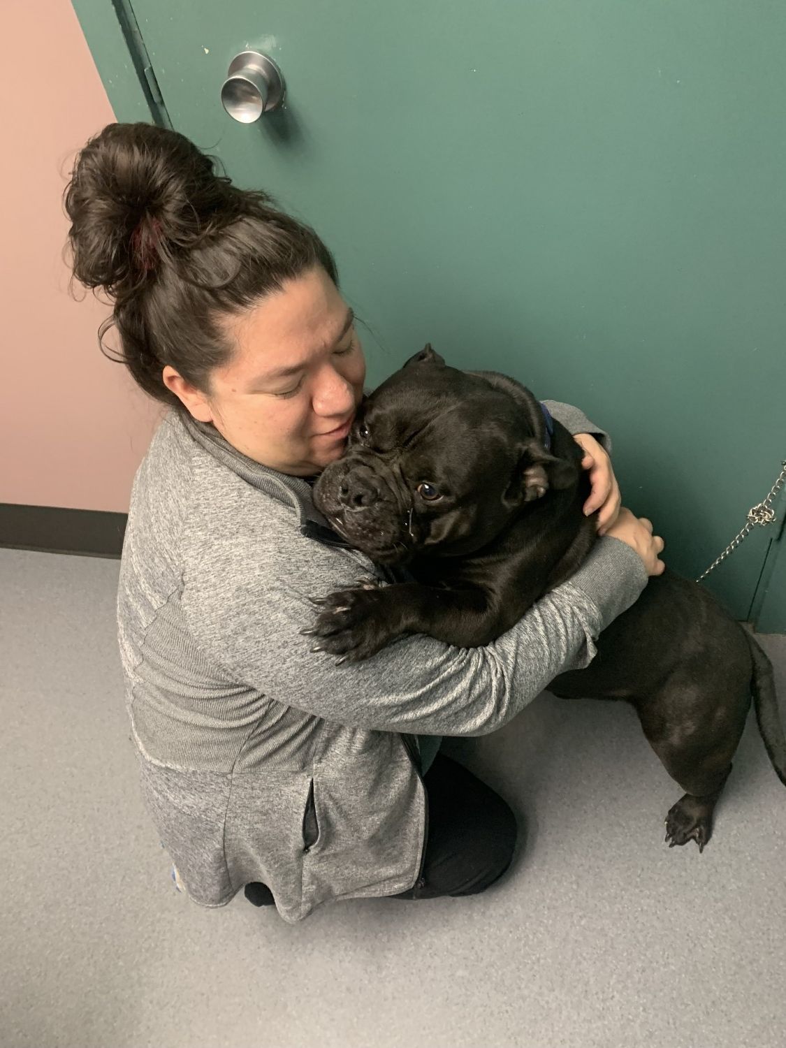 Woman holding black dog